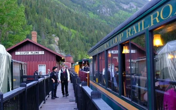 A Georgetown Loop Railroad steam train winding through the mountains at dusk
